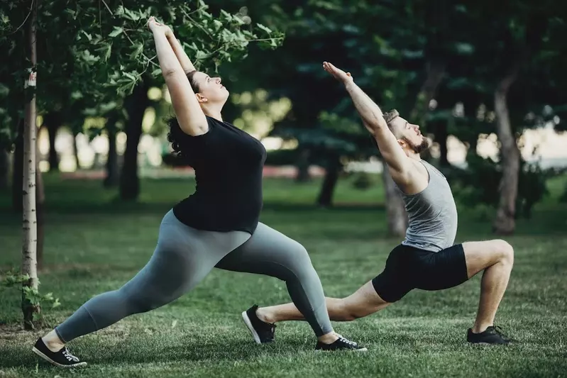 two younger people stretching on the grass